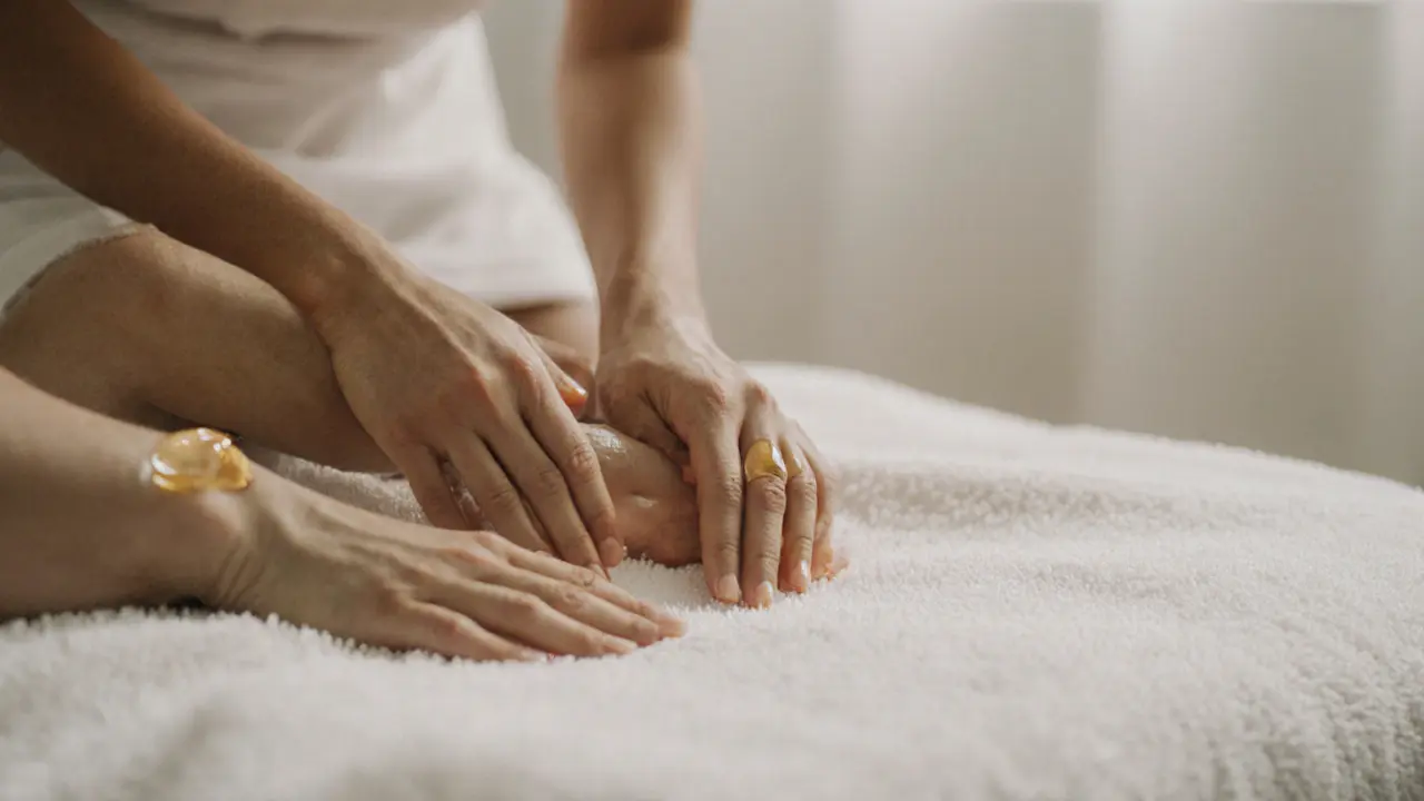 Hands massaging a forearm under a covered towel