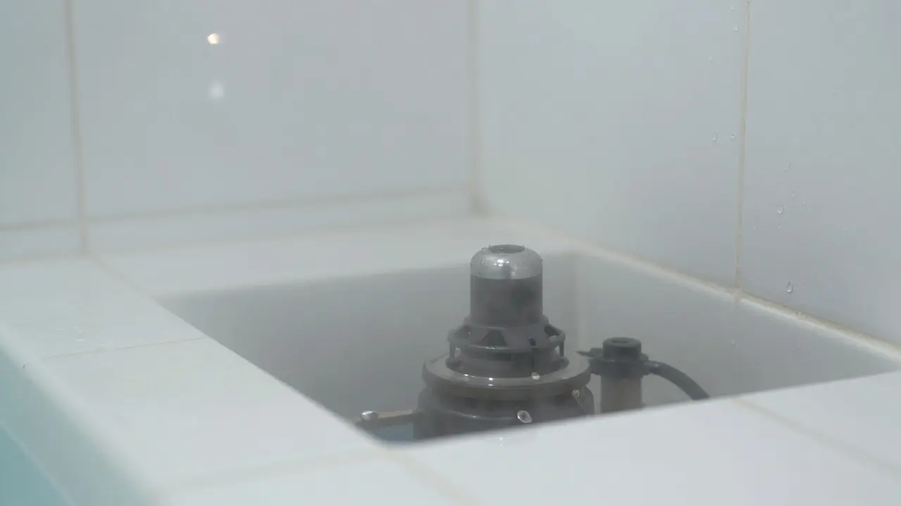 Close-up of condensation and steam rising from wet tiles in a humid spa room.